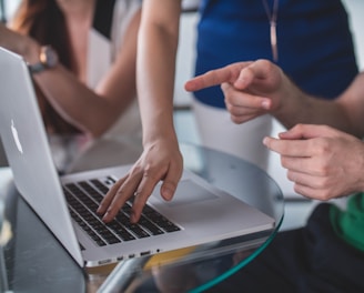 person touching and pointing MacBook Pro
